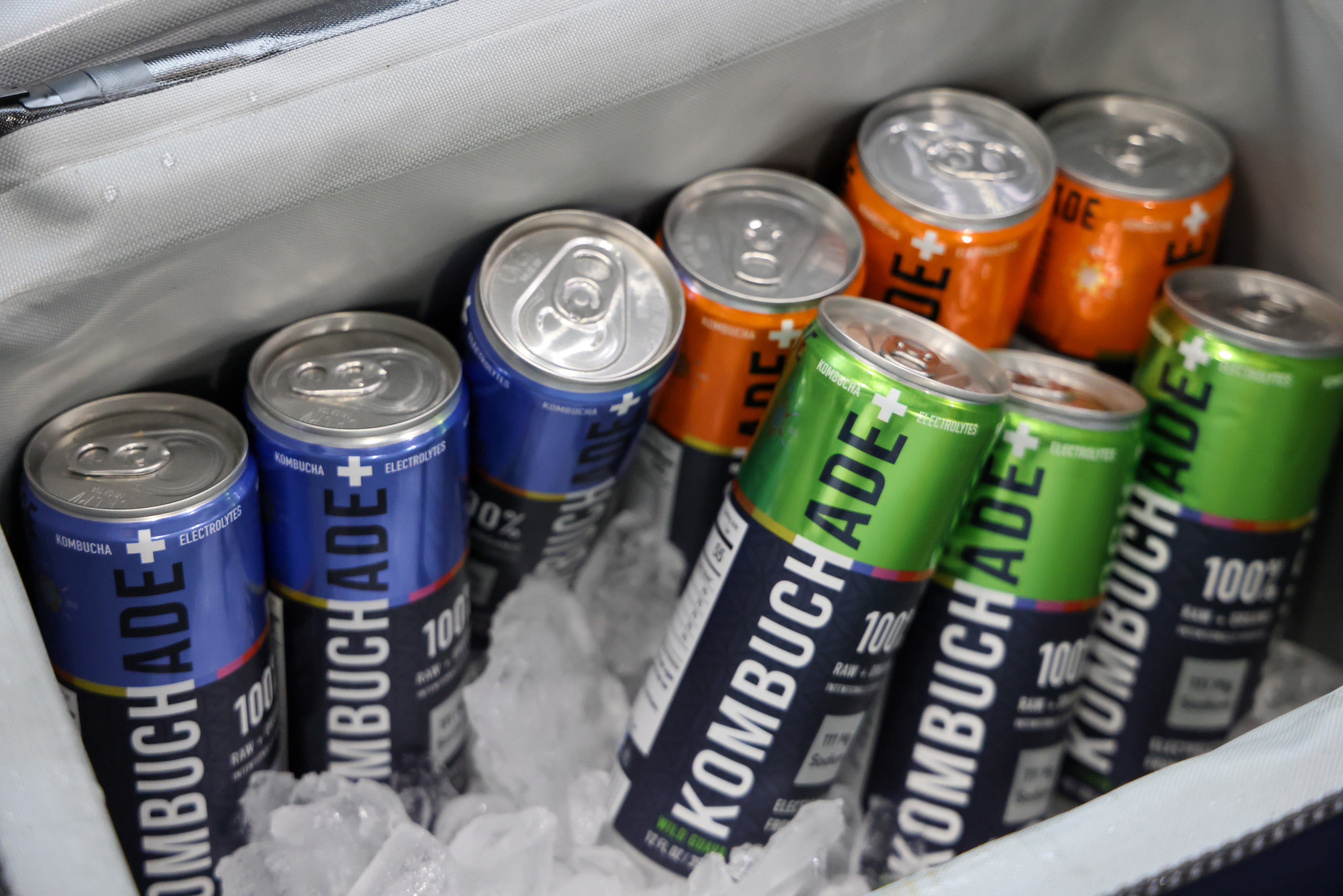 cans of all three flavors of Kombuchade in a cooler with ice