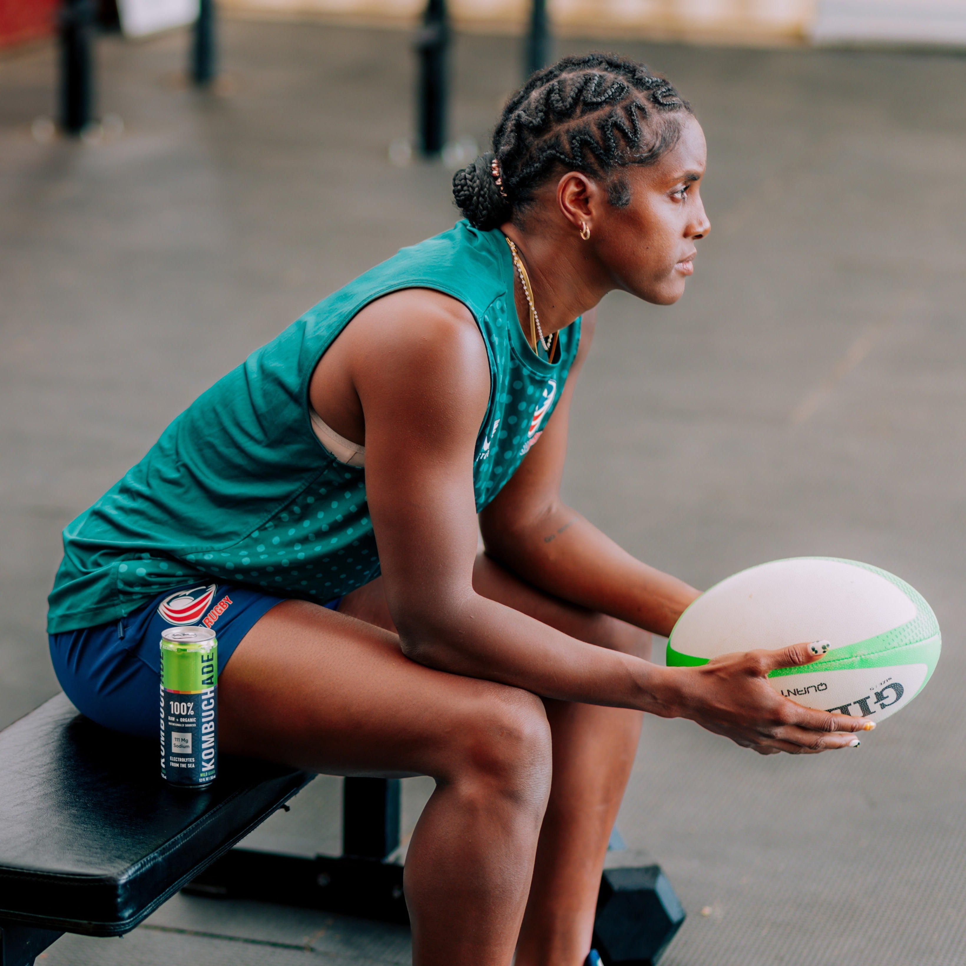 Naya Tapper USA rugby team athlete sitting with wild guava Kombuchade holding ball